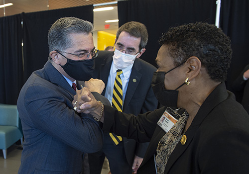 U.S. Secretary of Health and Human Services Xavier Becerra greets Sheryl Garland, chief of health impact for VCU Health System