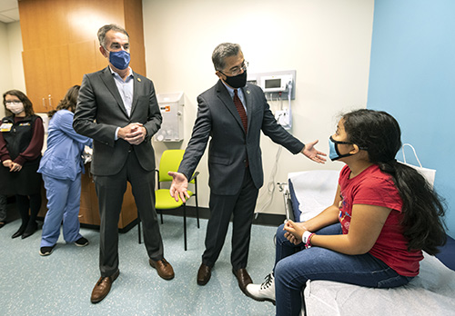 Virginia Gov. Ralph Northam, left, and U.S. Secretary of Health and Human Services Xavier Becerra greet Mary Picado