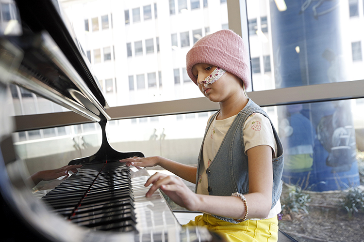 Ava Lester playing piano in the Children's Pavilion Sky Lobby