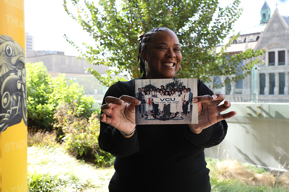 Dr. Crewe holding a picture of her and her high school classmates visiting VCU in the 1990s