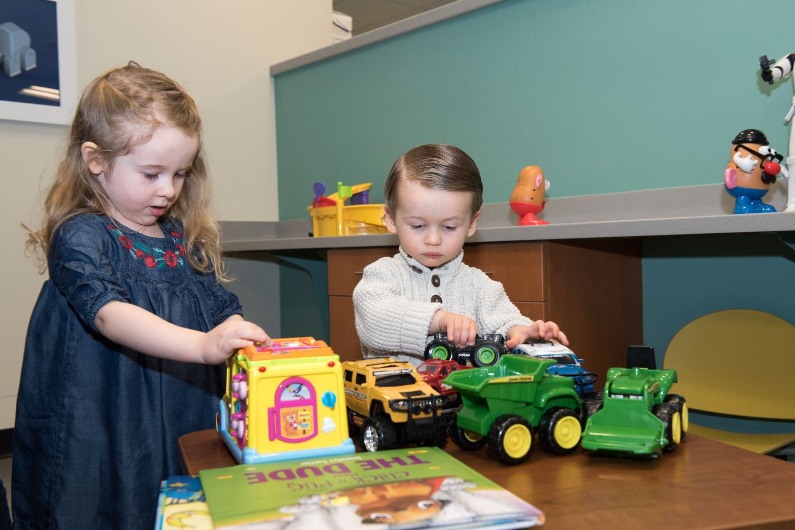 Obadiah and girl playing with toys in waiting room