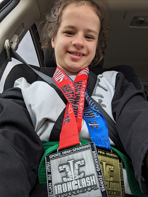 CHoR patient Emory wearing her martial arts medals