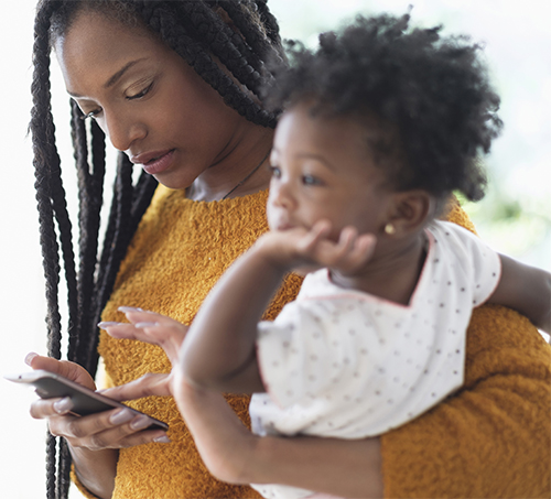 Mom holding phone and baby