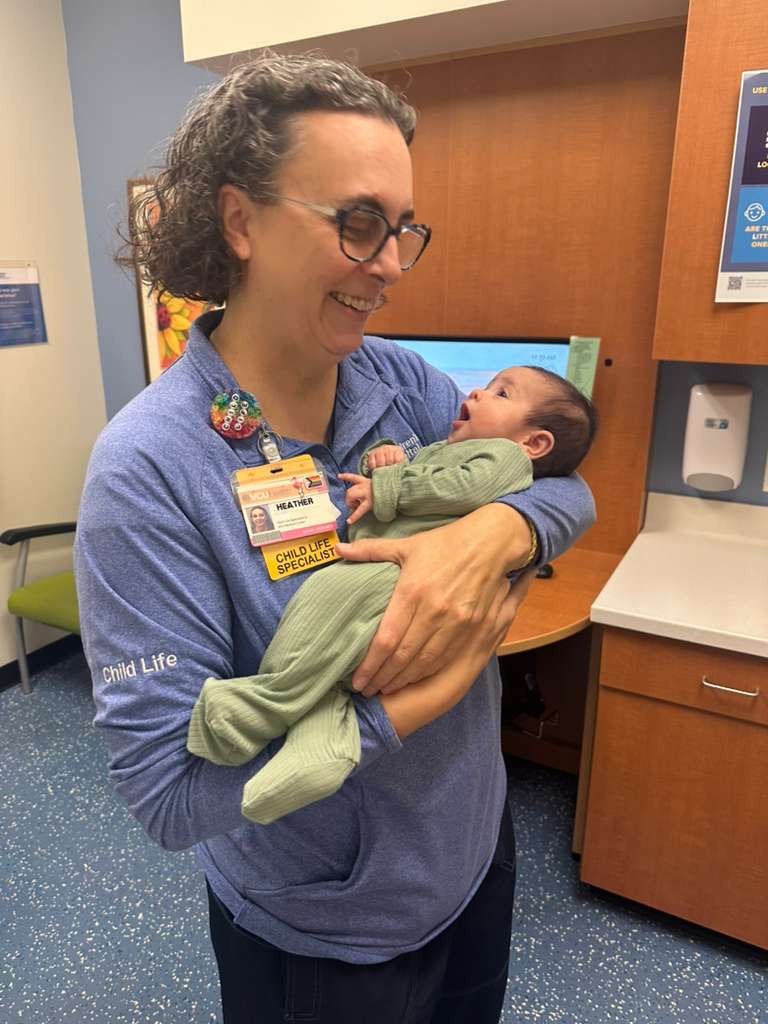 CHoR child life specialist Heather Rossi holding a baby