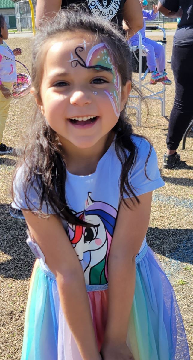 CHoR patient Isabel smiling outside with her face painted