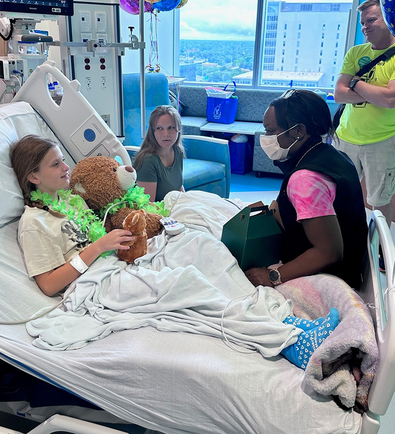 CHoR's Jeniece Roane talking to a patient in her Children's Tower hospital room