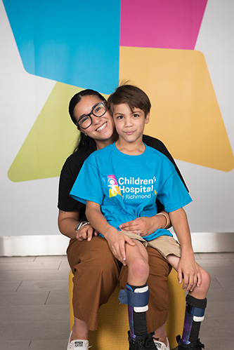CHoR patient Jonah Smith wearing a CHoR shirt and sitting on his mom's lap