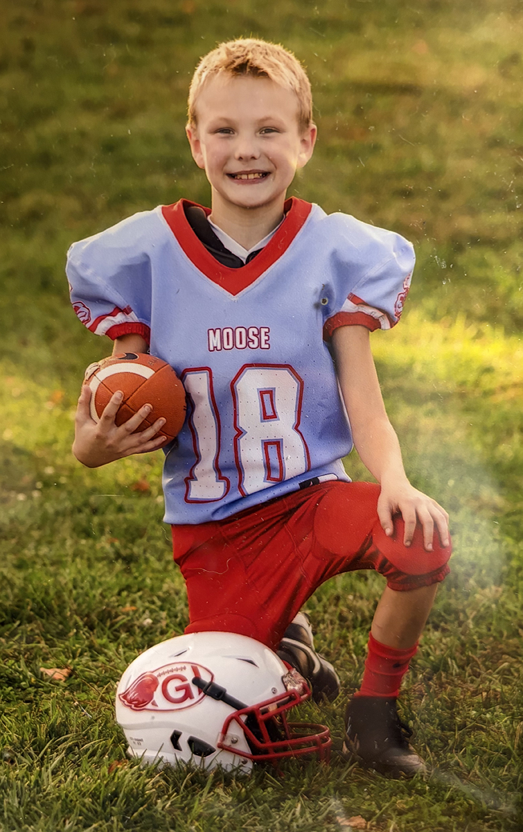 CHoR patient Keegan Bowles in his football uniform holding a football