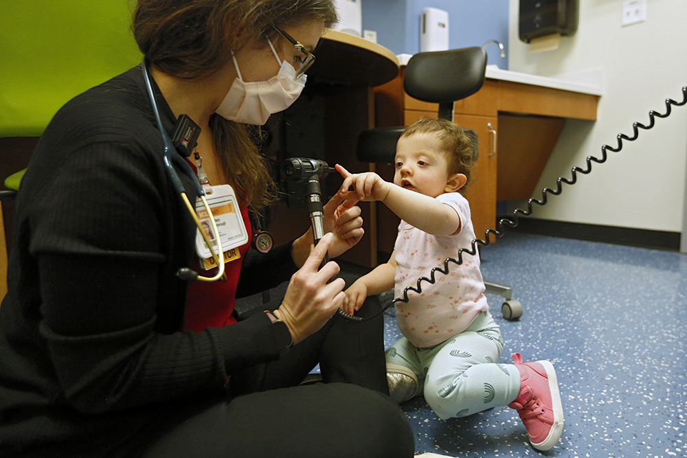 Dr. Tiffany Kimbrough sitting on the floor with a young patient