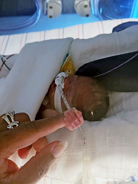 Tiny Lennox holing his mom's finger in the CHoR NICU