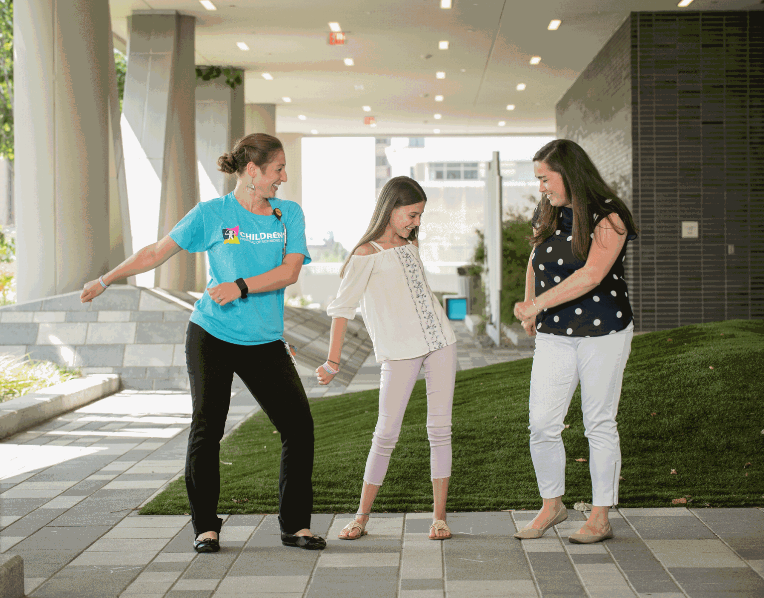 Lexie Hafey (center), who has been dancing competitively for four years, taught some moves to Siri Garrett, Certified Child Life Specialist (left), and Jessica Graham, RN, BSN, CPN, Pediatric Surgery RN, during a summer visit to Children’s Hospital of Richmond at VCU. (Photo by Doug Buerlein)