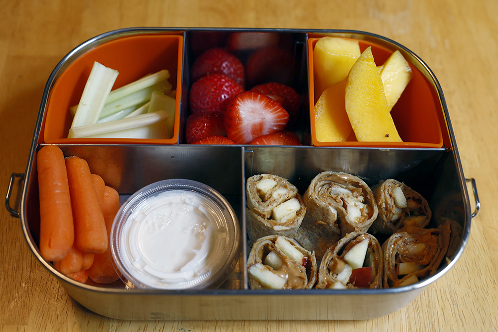 Lunchbox with peanut butter pinwheels and fruit and veggies