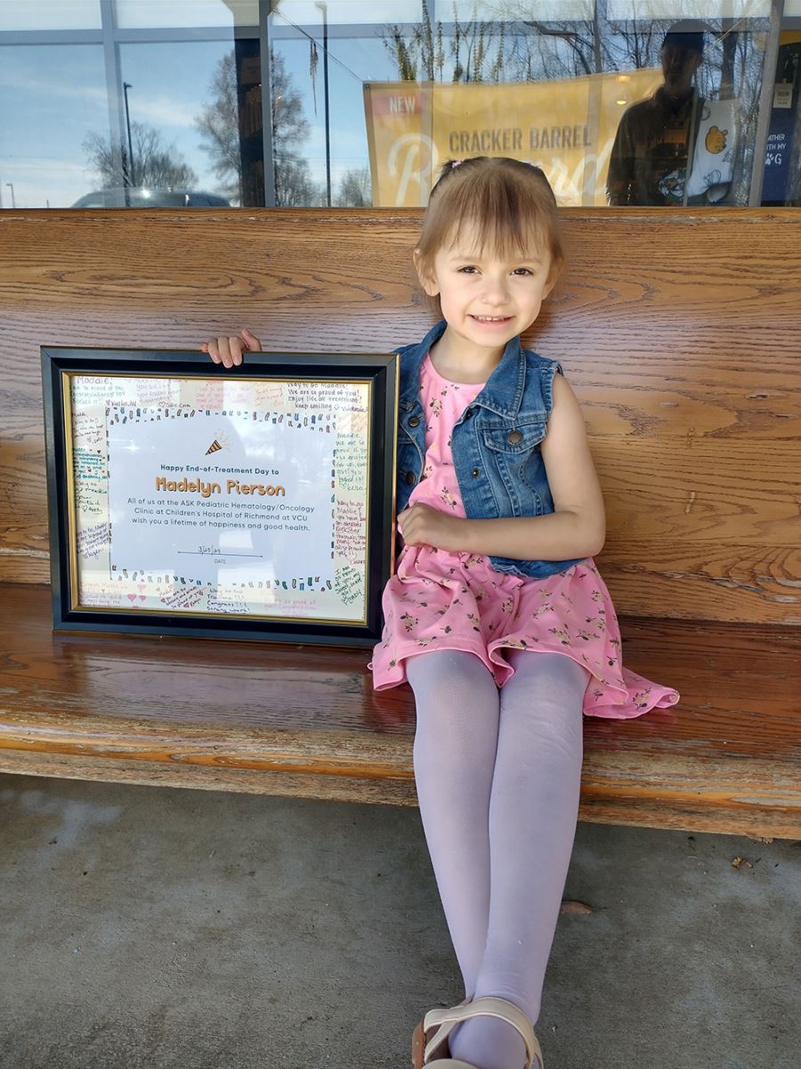 CHoR patient Maddie holding sign celebrating the end of her leukemia treatment