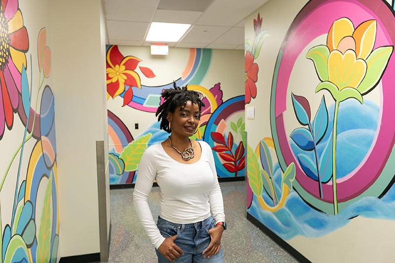 Richmond artist Jowarnise Caston in front of CHoR mural