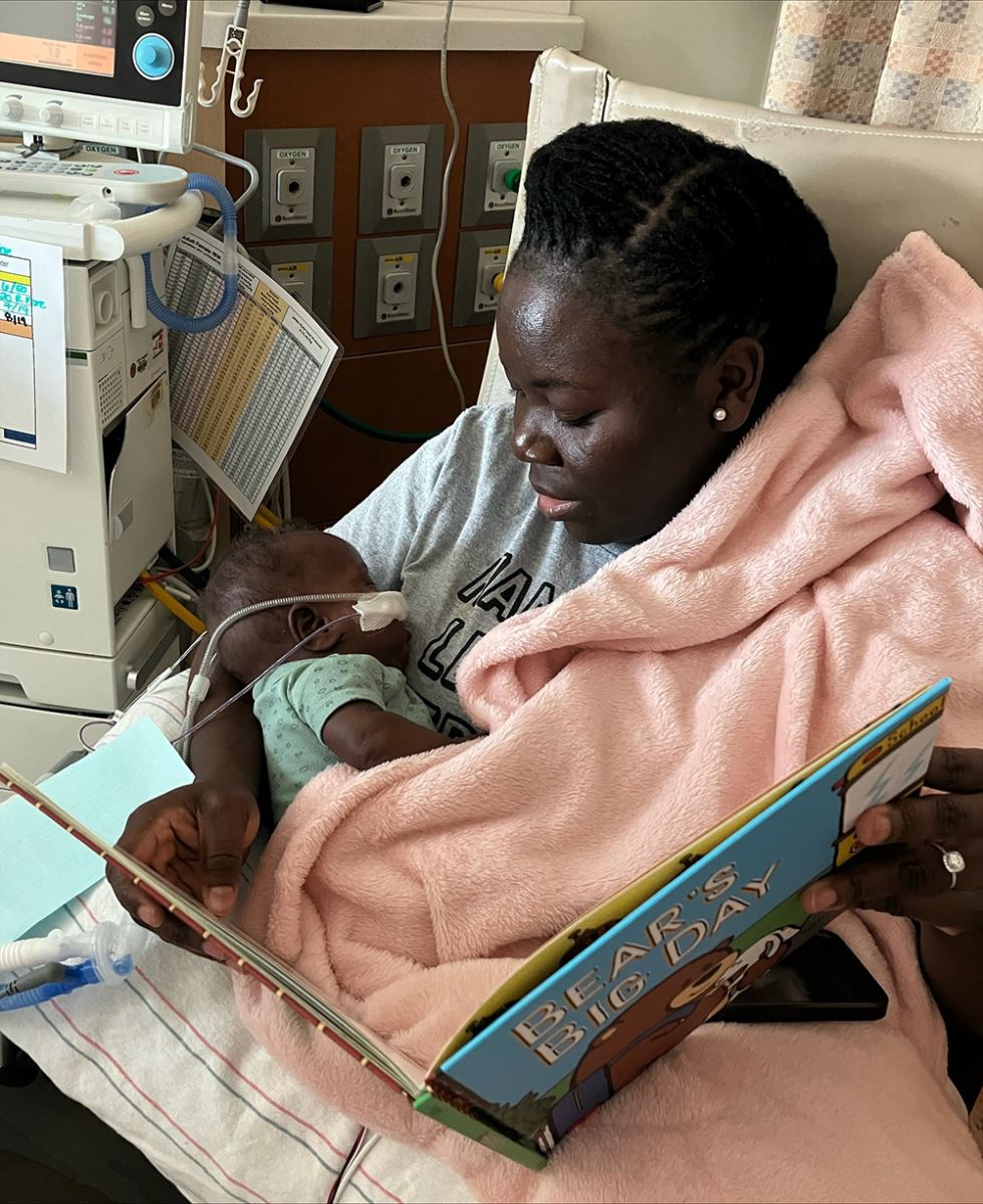 Mom reading a book to her baby in the CHoR NICU