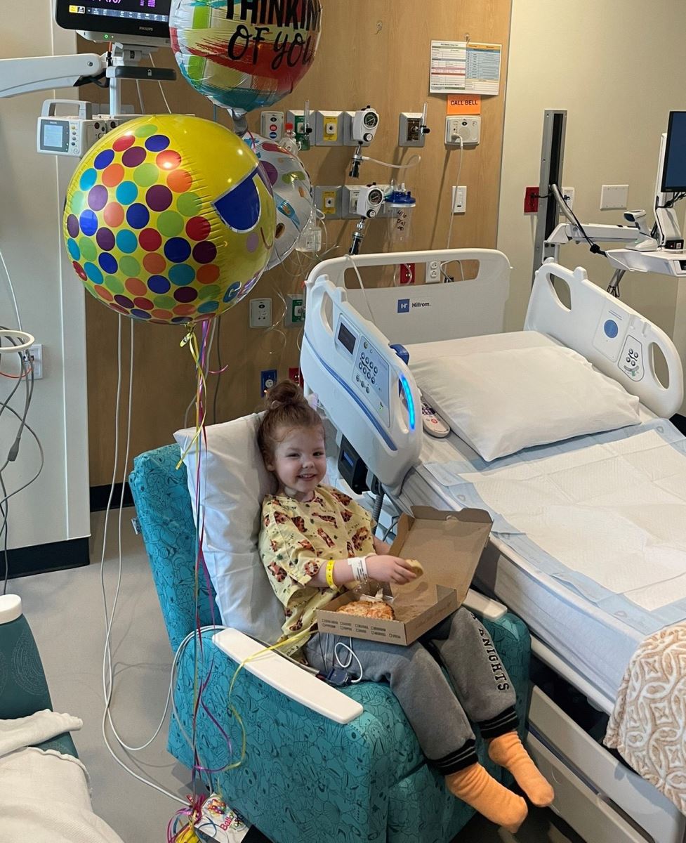 CHoR patient Olivia Rudesheim eating pizza in her Children's Tower room