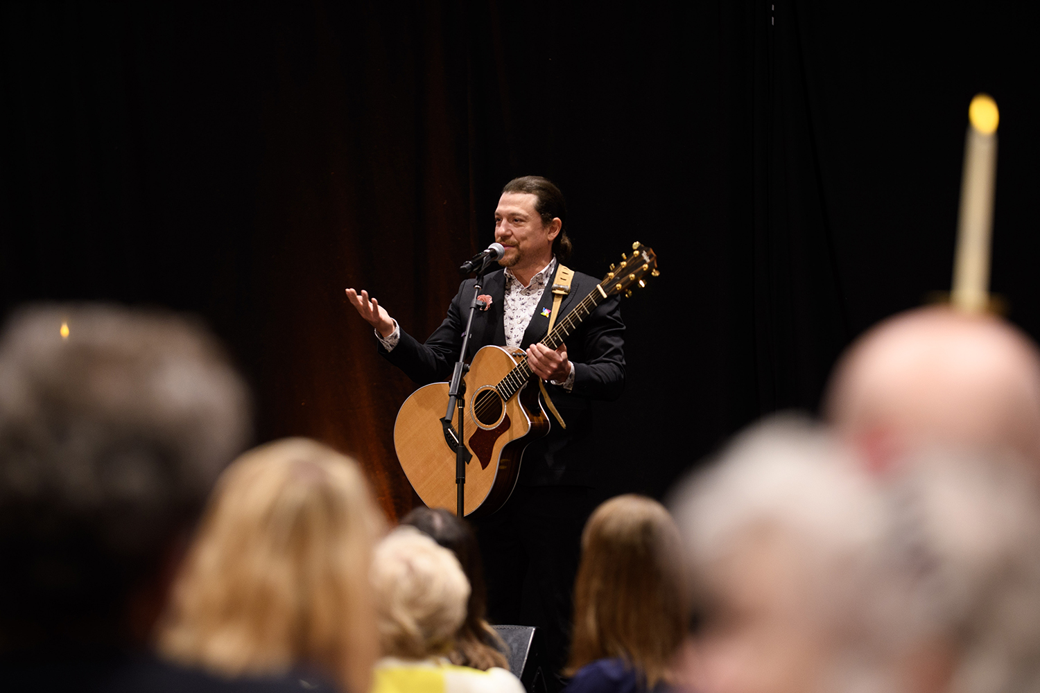 Miguel Cervantes holds his guitar as he performs for the crows at the CHF Words & Wisdom event