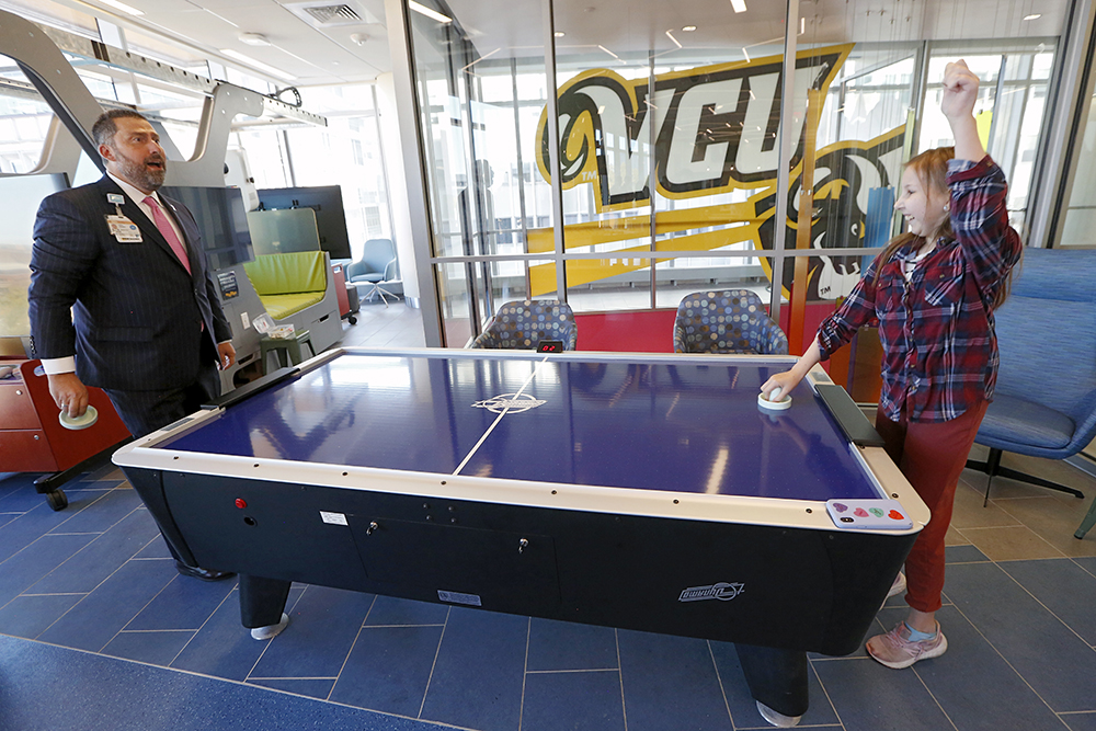 CHoR president Elias Neujahr losing a game of air hockey in the Child Life Zone